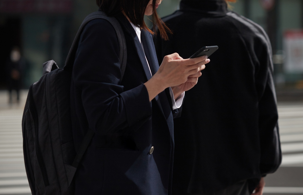 Business woman walking down street using Japanese meta