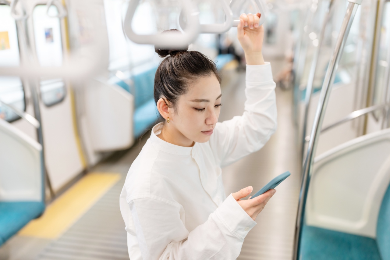 Millennial browsing SEO marketing in Japan in 2022 on Tokyo train
