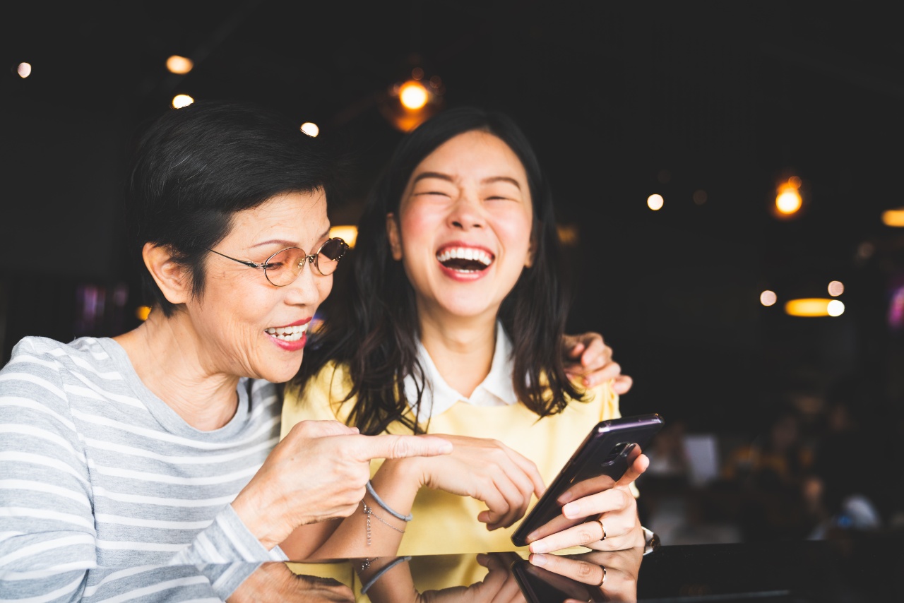 Mother and daughter laughing at LINE stickers and LINE advertising in Japan