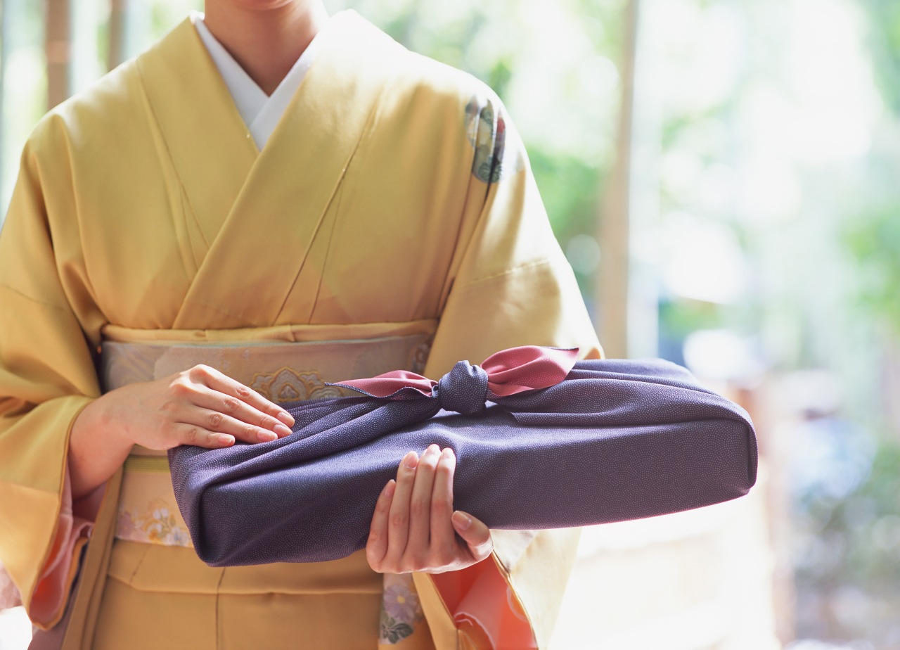 Woman holding gift and traditional item for Japanese holiday