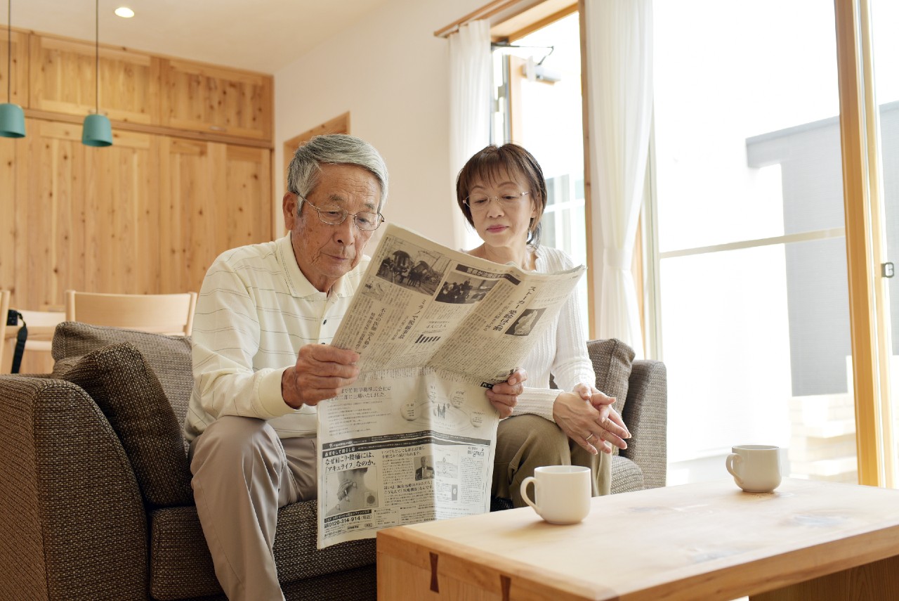 Elderly couple reading newspaper advertising in Tokyo