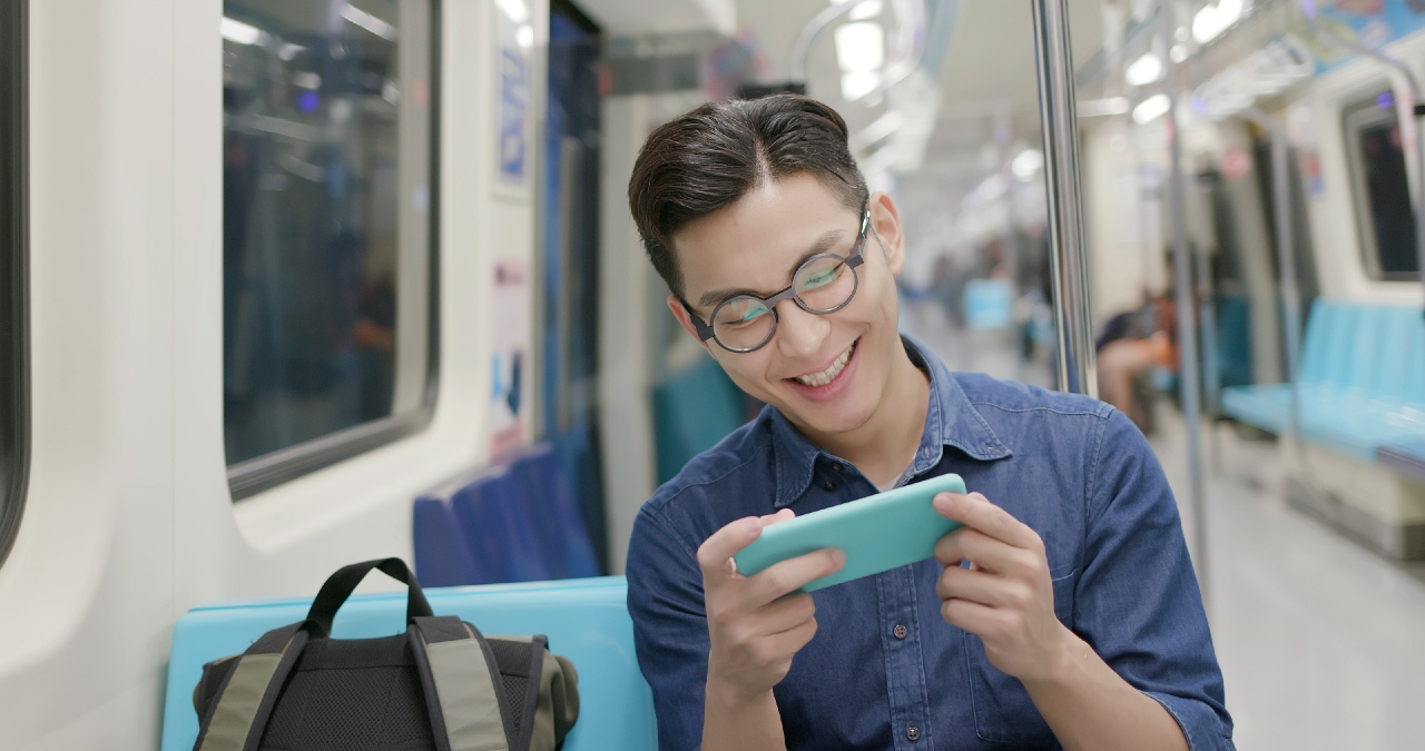 Japanese commuter enjoying mobile content and advertising in Tokyo