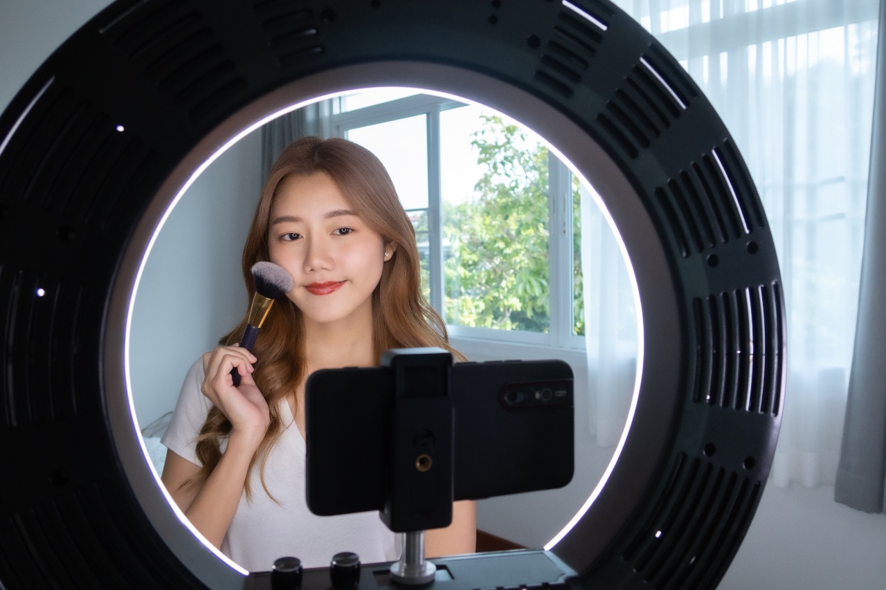 Woman influencer applying makeup for video TikTok ads in Japan