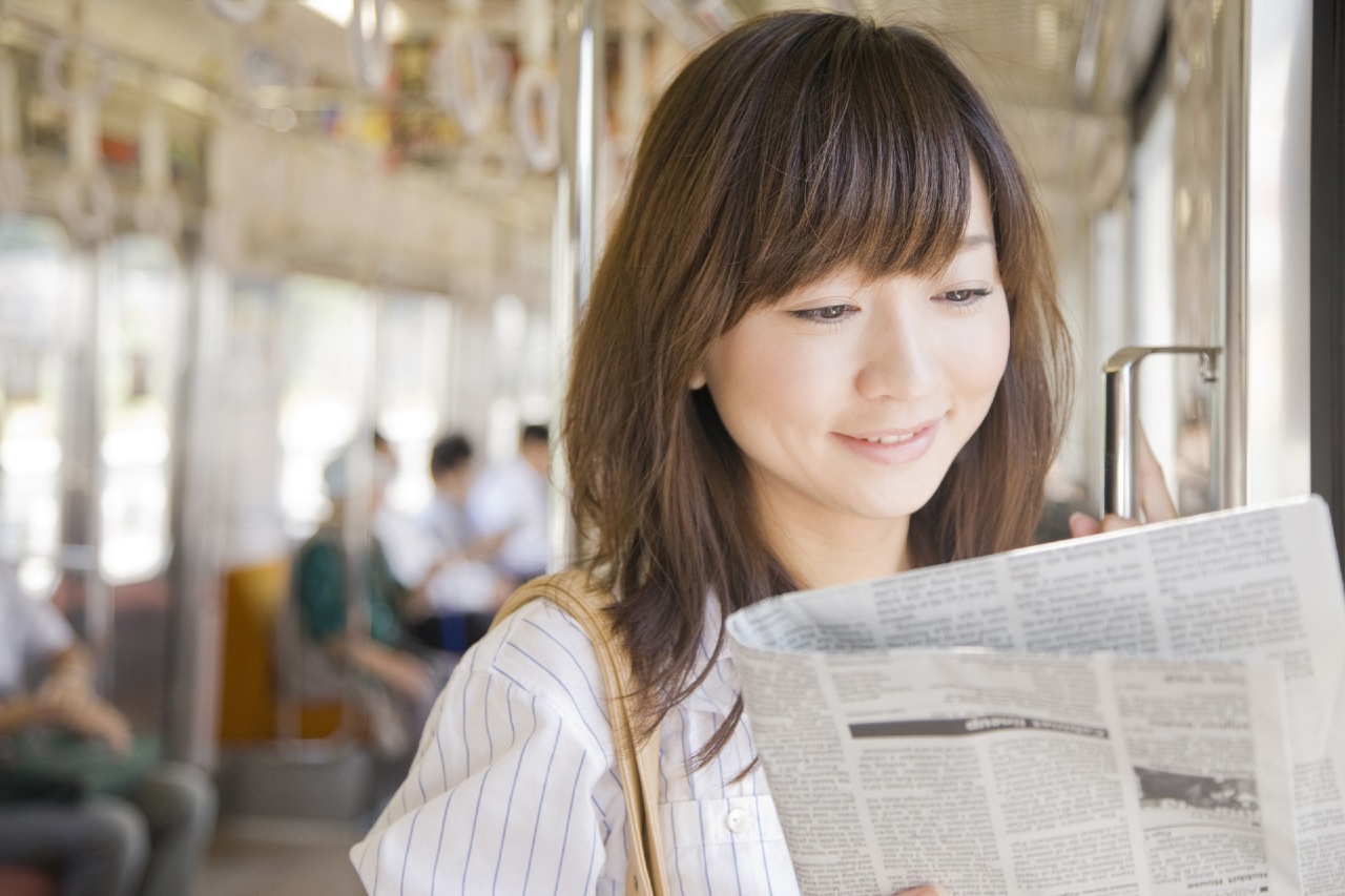 Woman on train reviewing promotional content released by PR agencies in Japan